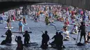 Orang-orang mengayuh papan stand-up paddle (SUP) mereka di sepanjang Griboyedov Channel  selama yang diberi nama Festival Fontanka-SUP di Sungai Moyka, St. Petersburg, Rusia, Sabtu, 6 Agustus 2022. Festival ini tidak hanya sebtas kegiatan olahraga namun juga rekreasi. (AP Photo/Dmitri Lovetsky)