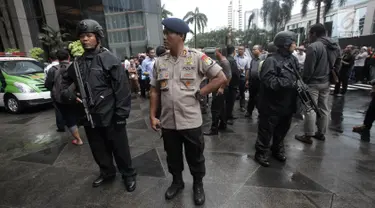 Petugas kepolisian bersenjata berjaga di sekitar lokasi Gedung BEI, Jakarta, Senin (15/1). Demi keamanan dan keselamatan, pihak keamanan menutup area sekitar lokasi gedung BEI yang ambruk. (Liputan6.com/Arya Manggala)