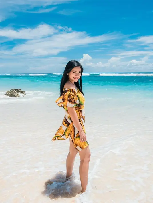 Off shoulder bermotif floral jadi pilihan OOTD Titi lainnya saat ke pantai. [Foto: IG/titi_kamall].