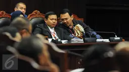 Gubernur DKI Basuki 'Ahok' Tjahaja Purnama (kanan) berbincang dengan kuasa hukumnya disela sidang lanjutan uji materiil Undang-Undang Pilkada mengenai cuti selama masa kampanye di MK, Jakarta, Kamis (15/9). (Liputan6.com/Faizal Fanani)