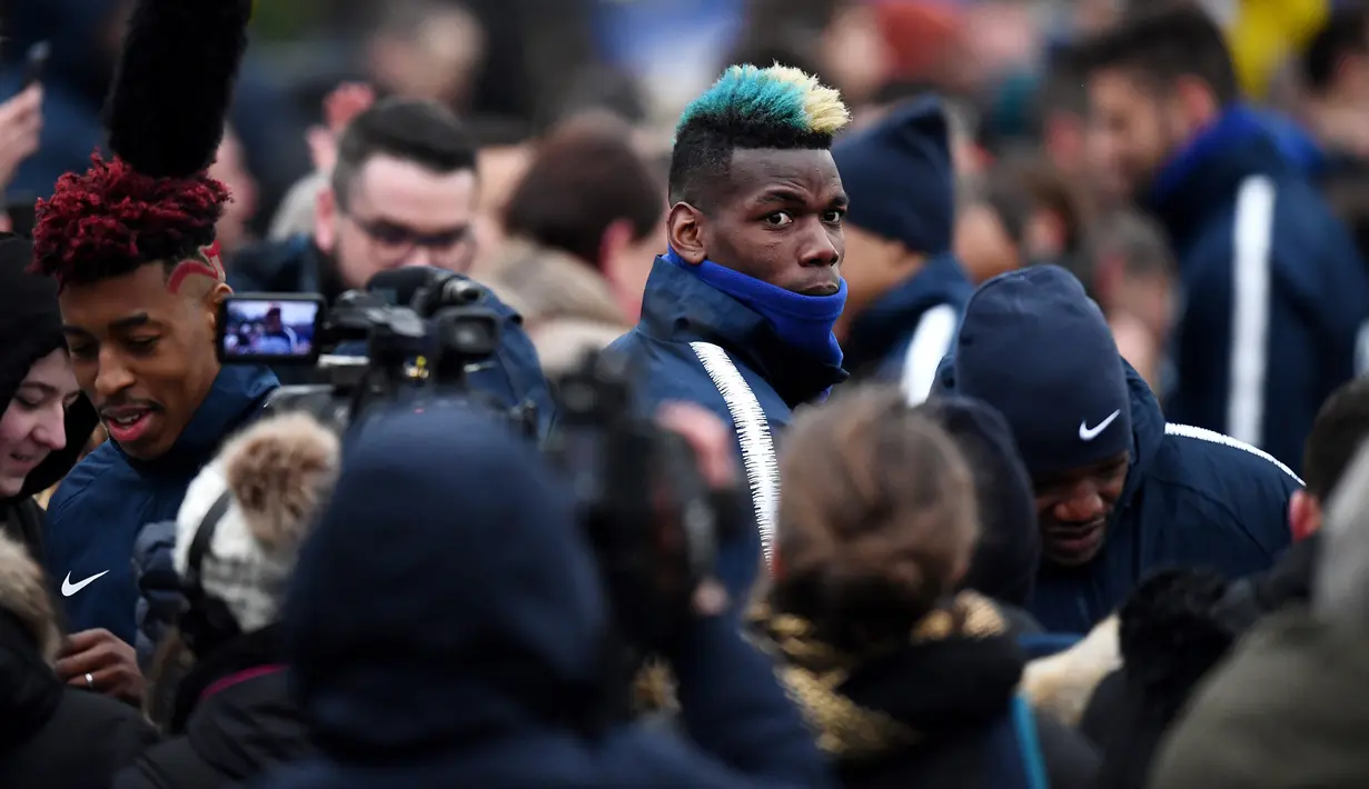Gelandang timnas Prancis Paul Pogba berada di kerumuni penggemar sebelum mengikuti sesi latihan di Clairefontaine-en-Yvelines, Paris (19/3). (AFP Photo/Franck Fife)