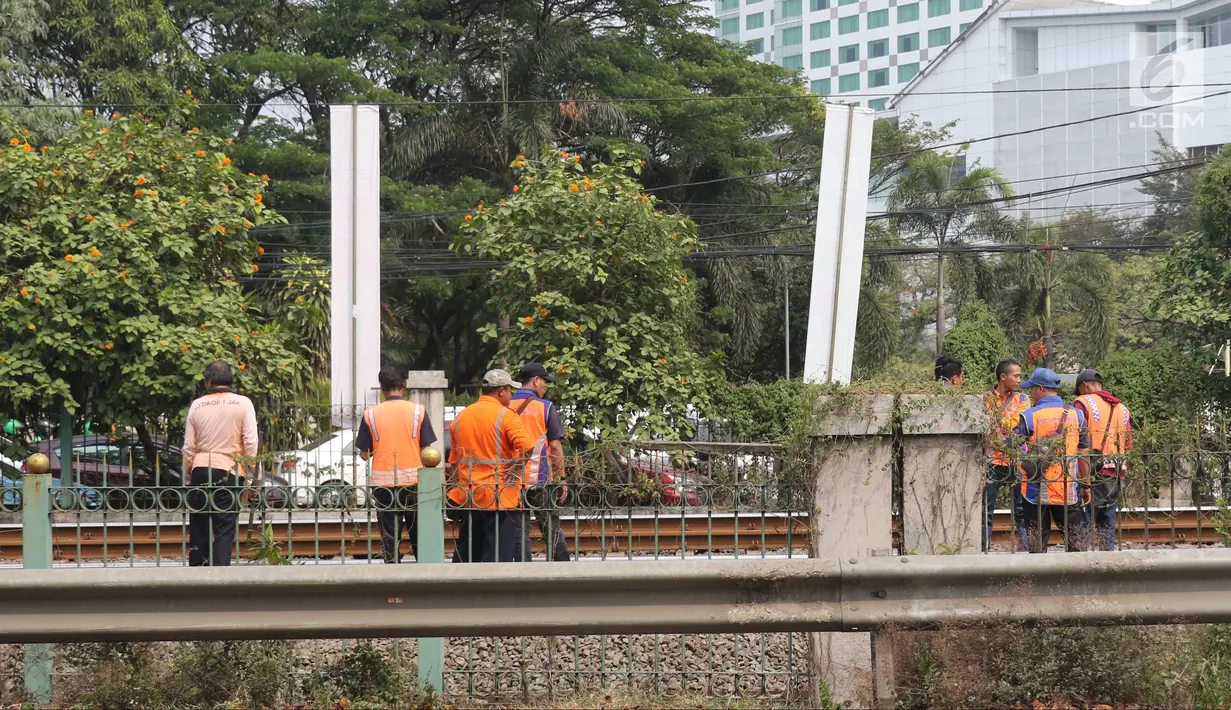 Sejumlah petugas KAI memeriksa rel kereta di dekat Stasiun Palmerah, Jakarta, Sabtu (13/10). PT Kereta Commuter Indonesia (KCI) meminta maaf mengenai anjloknya kereta KRL Tanah Abang menuju Parung Panjang. (Liputan6.com/Herman Zakharia)