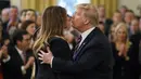 Presiden Donald Trump mencium Ibu Negara Melania Trump di Ruang Timur Gedung Putih di Washington (6/2/2020). Para senator AS memutuskan bahwa Trump tidak bersalah dalam sidang pemakzulan. (AP Photo/Patrick Semansky)