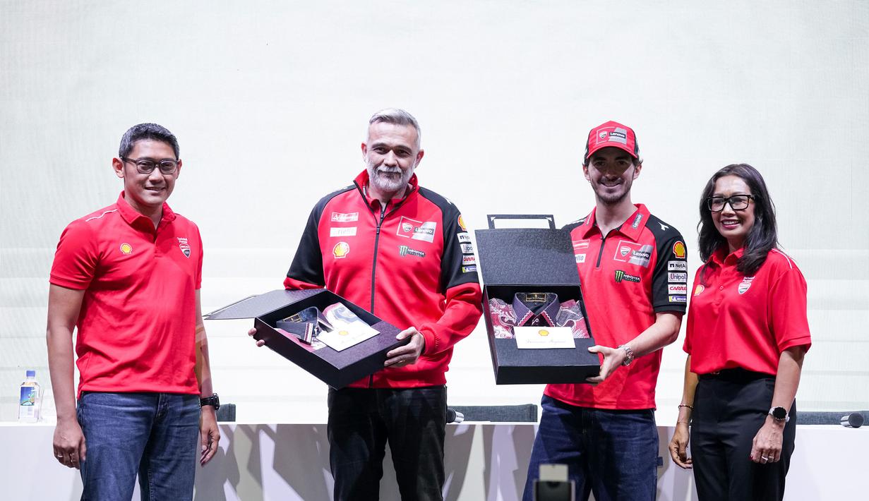 Presiden Direktur Shell Indonesia Ingrid Siburian (kanan) bersama dengan Vice President Marketing Lubricants Shell Indonesia Arie Satyanggoro (kiri) memberikan cenderamata kepada Ducati Corse Sporting Director Mauro Grassilli (kedua kiri) dan Ducati Rider Francesco Bagnaia (kedua kanan) berupa kemeja batik sebagai apresiasi dan semangat dalam rangka menyambut ajang kompetisi MotoGP 2024 pada acara Konferensi Pers Shell Advance dan Ducati Corse di Jakarta (25/09). (Dok. Shell Adavance)