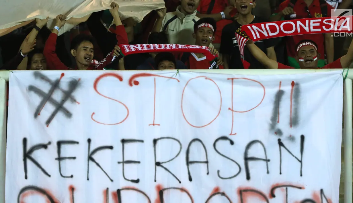 Spanduk keprihatinan terbentang di hadapan suporter yang menyaksikan laga Indonesia U-19 melawan China U-19 pada PSSI 88th U-19 International Tournament di Stadion Pakansari, Cibinong, Selasa (25/9). . (Liputan6.com/Helmi Fithriansyah)