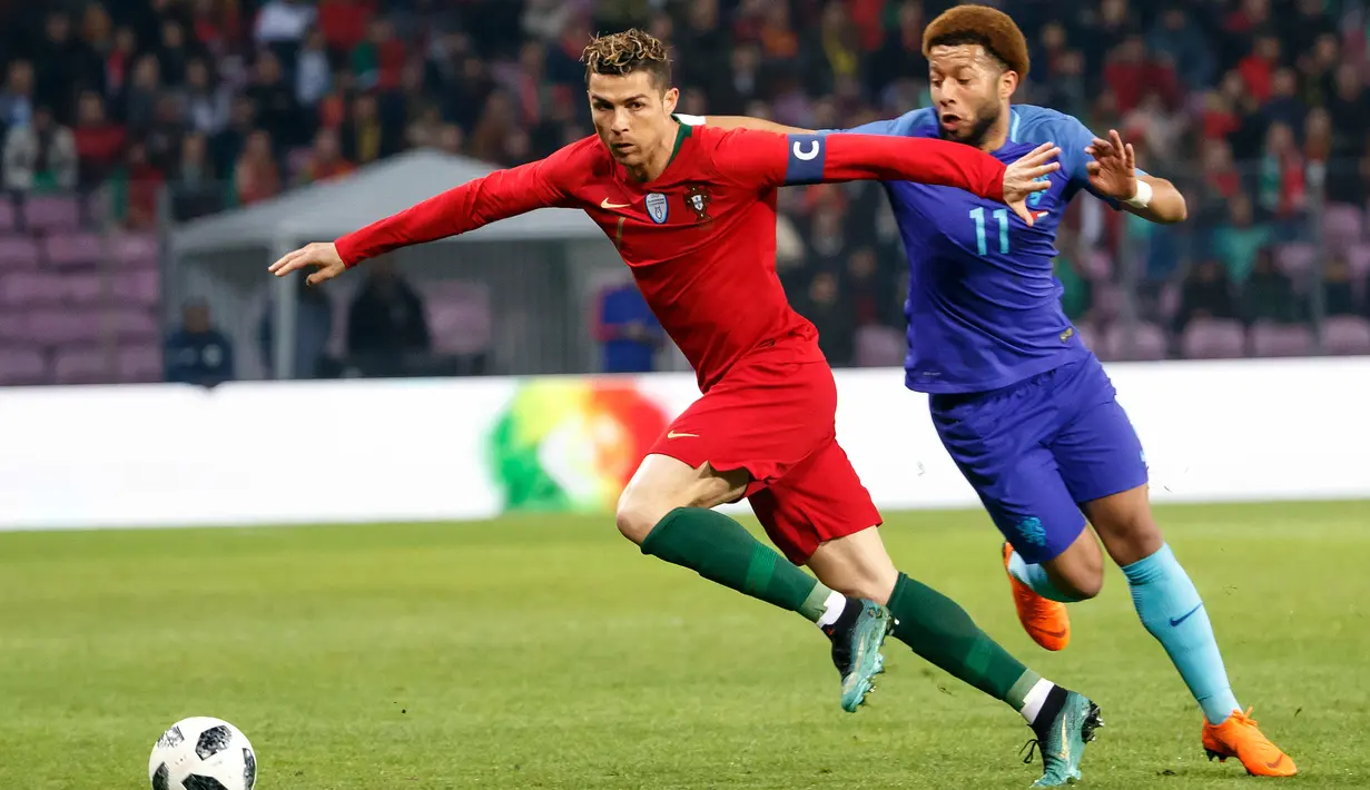 Pemain depan Portugal, Cristiano Ronaldo (kiri) bersaing bola dengan Tonny Vilhena asal Belanda pada laga persahabatan di Stadion Stade de Geneve, Jenewa, Swiss, Senin (26/3). Belanda bantai Portugal 3-0. (KEYSTONE/Salvatore Di Nolfi/Keystone via AP)