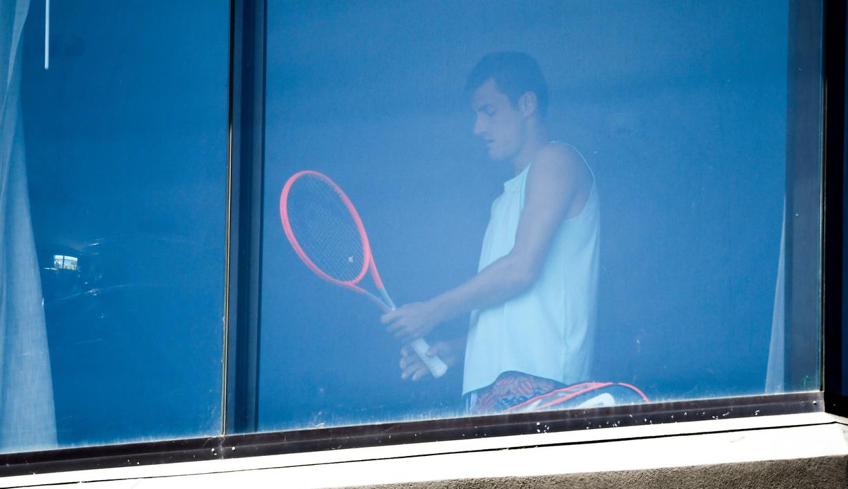 Petenis Australia, Bernard Tomic melakukan latihan dikamar hotel saat menjalani karantina selama dua minggu setelah kedatangannya di Melbourne, Minggu (17/1/2021). (Foto: AFP/William West)