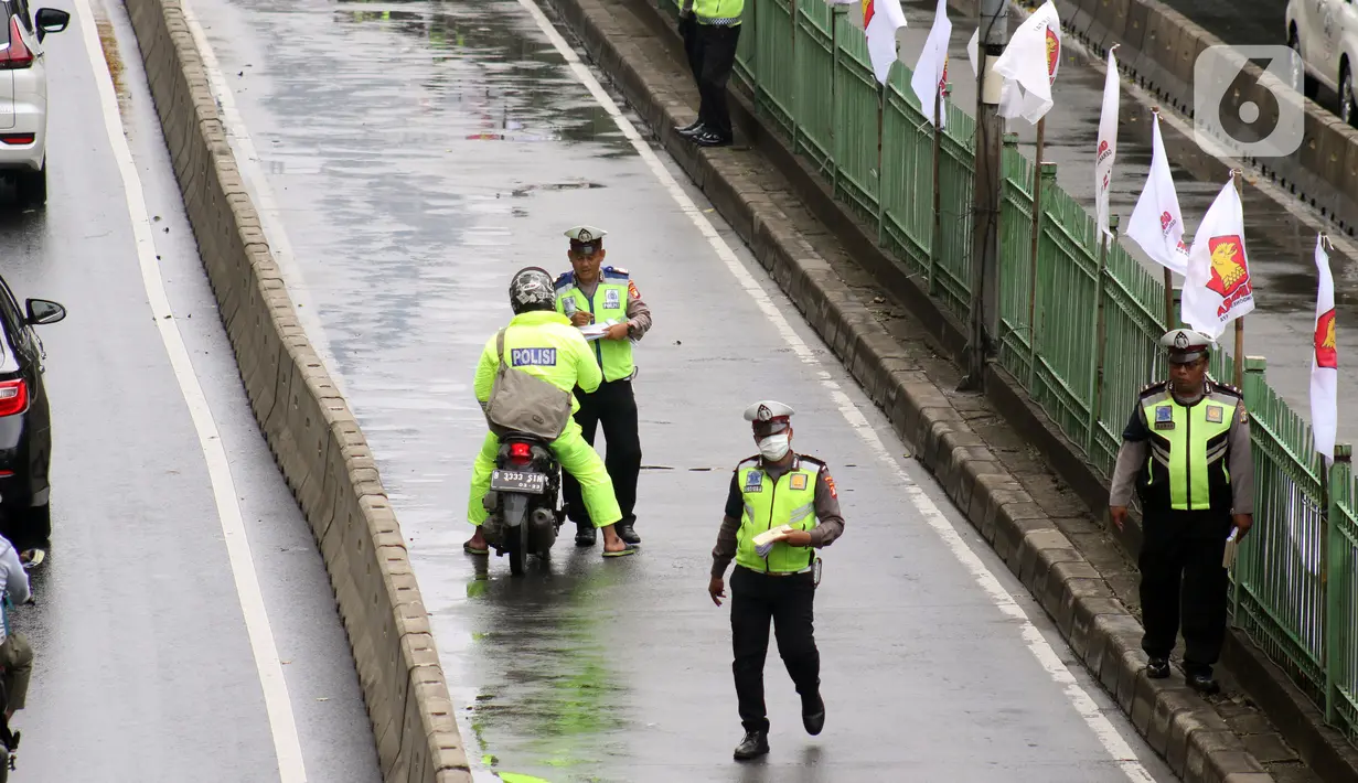 Petugas kepolisian lalu lintas merazia pengendara sepeda motor yang melintasi jalur bus Transjakarta di Jalan Sultan Agung, Manggarai, Jakarta, Kamis (6/2/2020). Meski melanggar, sebagian pengguna jalan secara sengaja masuk dan menggunakan jalur khusus bus tersebut. (Liputan6.com/Helmi Fithriansyah)