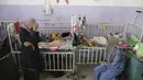 Amira Al-Jojo (kiri) berdiri di samping putranya yang berusia 10 bulan, Yousef Al-Jojo, yang menderita kekurangan gizi di Rumah Sakit Martir Al-Aqsa, tempat ia menjalani perawatan, di Deir al-Balah di Jalur Gaza tengah pada Sabtu, 1 Juni 2024. (AP Photo/ Jehad Alshrafi)
