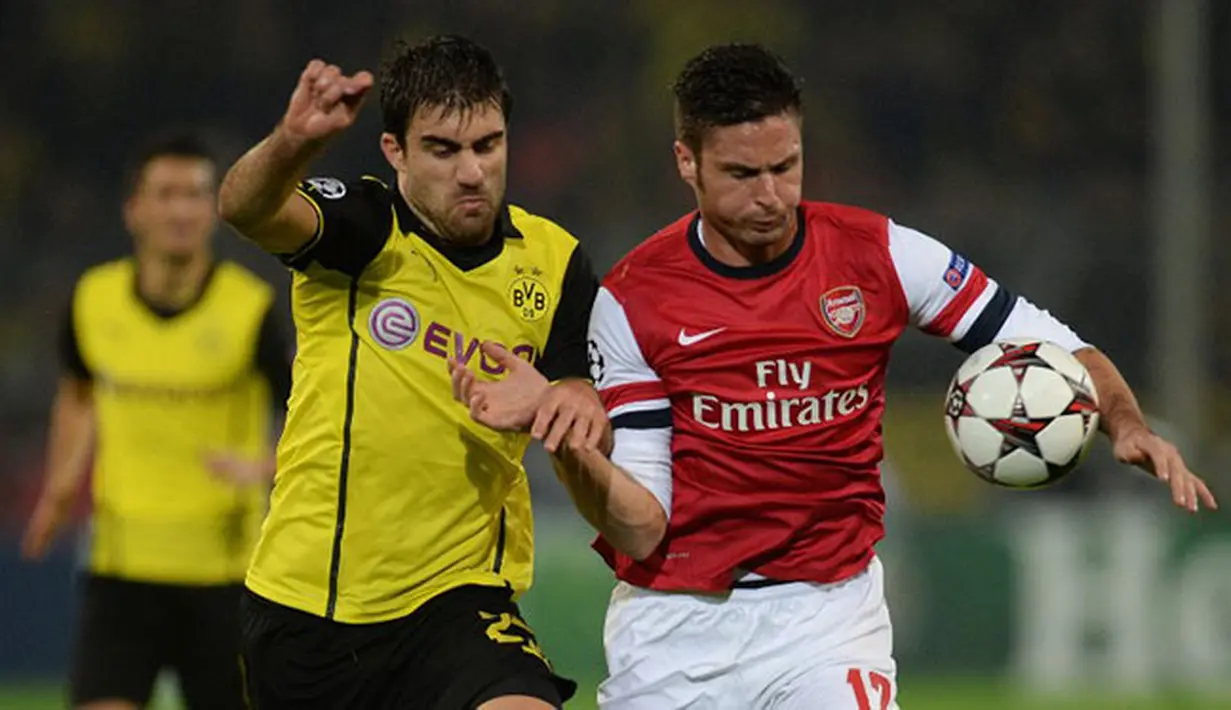 Olivier Giroud dihadang pemain Dortmund Sokratis pada Liga Champions Grup F antara Borussia Dortmund vs Arsenal di Dortmund,(6/11/2013).(AFP/Patrik Stollarz)