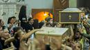 Pelayat membawa peti jenazah para korban tewas dalam kebakaran gereja kristen koptik di Gereja Santa Perawan Maria, Kairo, Provinsi Giza, Mesir, 14 Agustus 2022. Kebakaran gereja kristen koptik di Mesir memaksa para jemaah melompat keluar dari jendela. (Khaled DESOUKI/AFP)