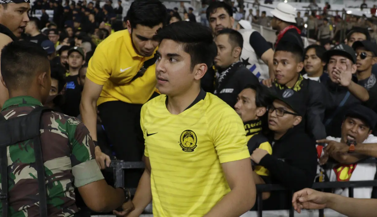 Lemparan benda-benda yang dilakukan suporter Timnas Indonesia membuat keselamatan para pendukung Malaysia terancam hingga terpaksa dievakuasi. (Bola.com/Vitalis Yogi Trisna)
