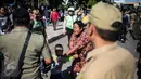 Seorang ibu bersama anaknya pemilik gerobak yang diamankan melawan dalam penertipan pedagang kaki lima (PKL) di kawasan Stasiun Kota Tua, Jakarta, Selasa (25/10). (Liputan6.com/Faizal Fanani)