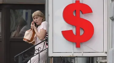 Seorang wanita meninggalkan kantor penukaran mata uang di St. Petersburg, Rusia, Kamis (6/7/2023). Presiden Rusia Vladimir Putin mengatakan ekonomi Rusia berkinerja lebih baik dari yang diperkirakan. (AP Photo/Dmitri Lovetsky)