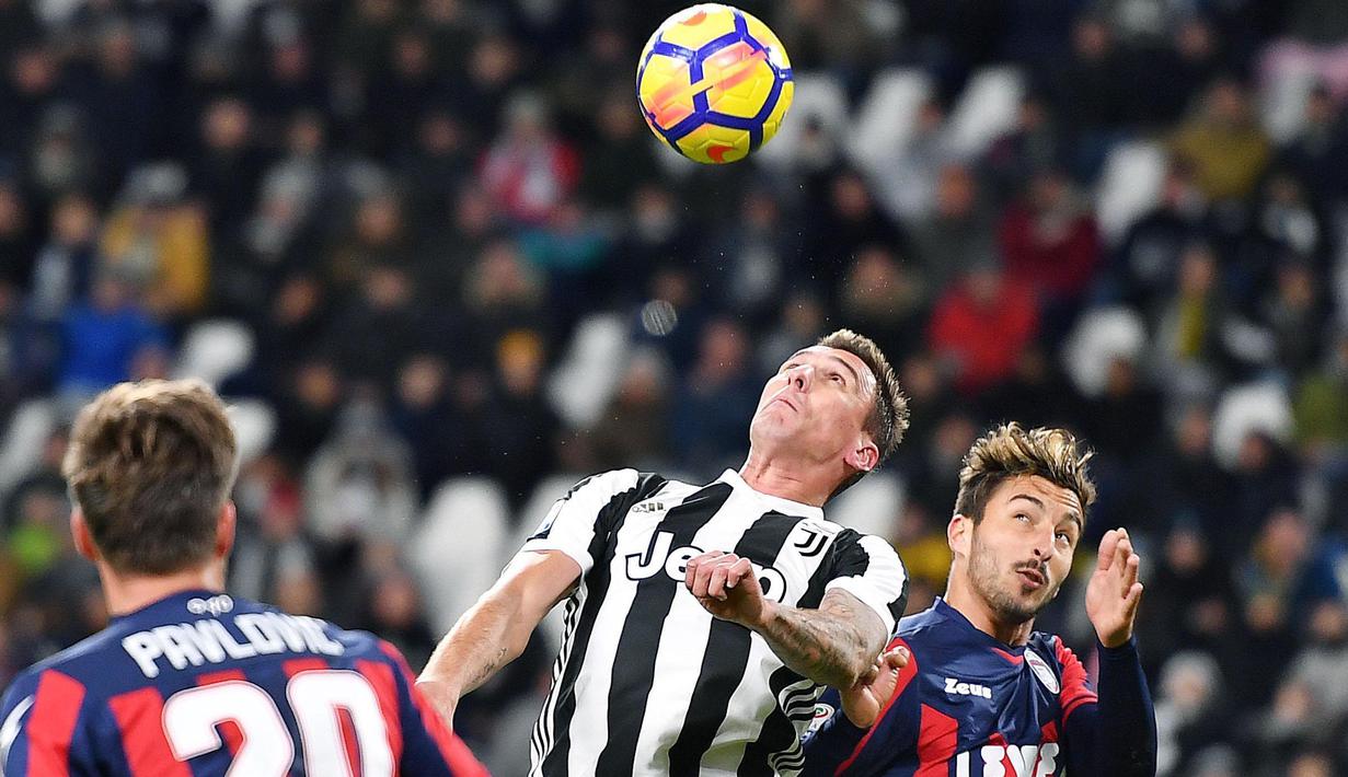 Aksi pemain Juventus, Mario Mandzukic (tengah) berusaha menyundul bola saat melawan Crotone pada lanjutan Premier League di Allianz Stadium, Turin, Italy, (26/11/2017). Juventus menang 3-1. (Alessandro Di Marco/ANSA via AP)