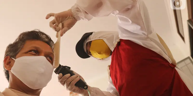 FOTO: Cegah Corona, Tukang Cukur di Depok Pakai APD