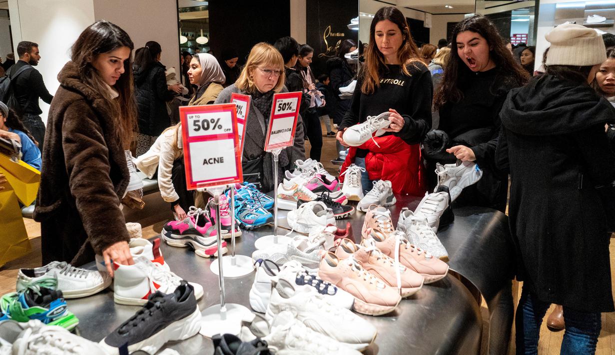 Pemburu diskon melihat sepatu selama Boxing Day di department store Selfridges, London, Kamis (26/12/2019). Boxing Day merupakan tradisi hari belanja terbesar tahunan yang diperingati setiap 26 Desember atau sehari setelah Natal dan menjadi hari libur nasional di Inggris. (Niklas HALLE'N/AFP)