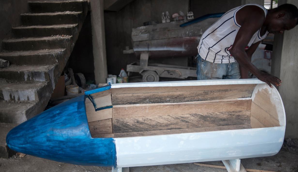 Pekerja menyelesaikan peti mati berbentuk pena di Hello Design Works Coffin, Ibu Kota Ghana, 10 Oktober 2016. Sejak puluhan tahun, masyarakat Kota Accra memesan peti mati yang melambangkan kehidupan orang yang sudah meninggal. (Stefan HEUNIS/AFP)