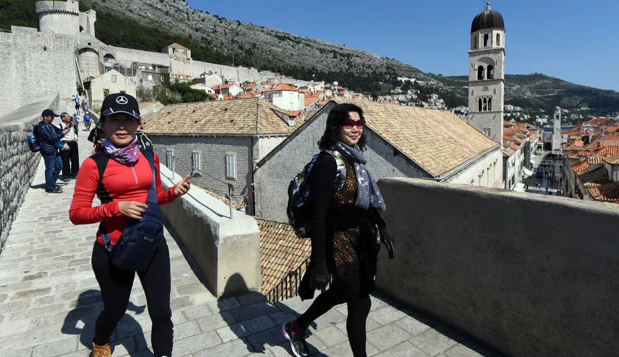 Wisatawan berjalan di atas benteng kota tua Dubrovnik pada 28 Maret 2019. Tahun lalu lebih dari 1,2 juta turis mengunjungi Dubrovnik, kota yang paling banyak dikunjungi di Kroasia. (Denis LOVROVIC / AFP)