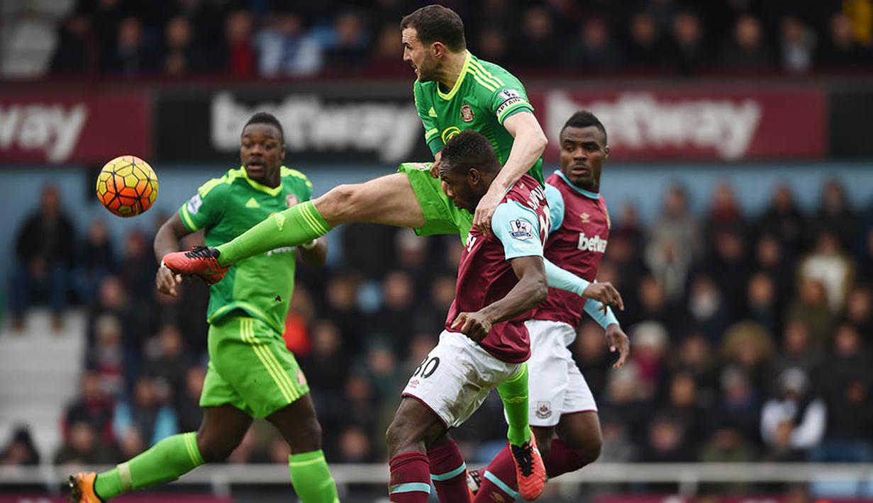 3. Bek Sunderland, John O'Shea, berebut bola dengan pemain West Ham, Michail Antonio pada laga Liga Premier Inggris di Stadion Upton Park, Sabtu (27/2/2016). West Ham berhasil menaklukan Sunderland 1-0. (Reuters/Tony O'Brien)