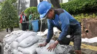 Petugas mengangkat endapan pasir saat membersihkan gorong-gorong di Jalan Gatot Subroto, Jakarta, Jumat (10/3). PHL dari Suku Dinas Sumber Daya Air (Sudin SDA) Jaksel kembali dikerahkan untuk membersihkan saluran di kawasan ini (Liputan6.com/Yoppy Renato)