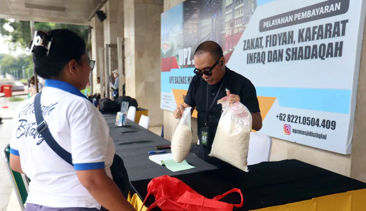 Menunaikan zakat fitrah merupakan langkah penting untuk menyempurnakan ibadah yang dilakukan sepanjang bulan suci Ramadan. Tampak dalam foto, petugas Unit Pengelola Zakat (UPZ) melayani pembayaran zakat, fidyah, kafarat, infaq, dan shadaqah di teras Masjid Istiqlal, Jakarta, Minggu 15 Maret 2026. (Kapanlagi.com/Budy Santoso)