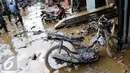 Sebuah sepeda motor dilumuri lumpur usai banjir menggenangi komplek Pondok Gede Permai Jatiasih, Bekasi, Jumat (22/04). (Liputan6.com/Fery Pradolo)