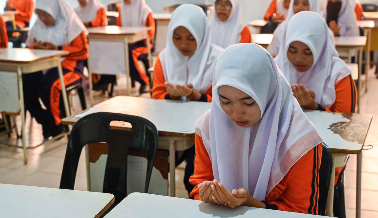 Sejumlah siswa Sekolah Menengah Atas (SMA) berdoa sebelum mengikuti simulasi gempa bumi dan tsunami untuk memperingati Hari Kesadaran Tsunami Sedunia di Lhoknga, Provinsi Aceh, pada Rabu 5 November 2025. Kegiatan ini seringkali melibatkan berbagai pihak, termasuk BMKG, BPBD (Badan Penanggulangan Bencana Daerah), PMI, TNI, Polri, pemerintah daerah, pelajar, dan masyarakat setempat. (CHAIDEER MAHYUDDIN/AFP)