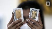 Pramuniaga menunjukkan emas batangan PT Aneka Tambang (Antam) Tbk di sebuah gerai emas, Jakarta, Senin (18/1/2021). Pada hari ini, harga emas Antam turun menjadi Rp 944 ribu per gram. (Liputan6.com/Johan Tallo)