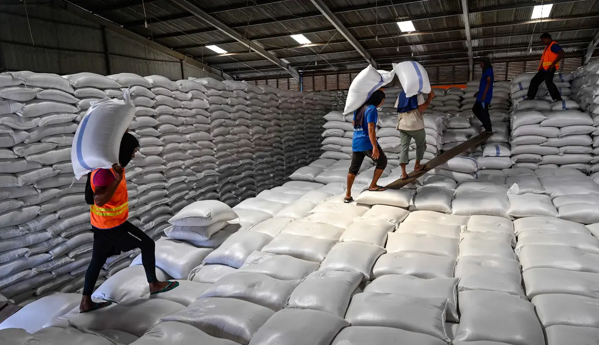 Penggunaan CBP yang dikelola Perum Bulog di tiga provinsi tersebut sedang diintensifkan untuk pelaksanaan program bantuan pangan reguler dan nonreguler. Tampak dalam foto, para pekerja menangani karung-karung beras†di gudang Badan Urusan Logistik (Bulog) di Lambaro, Provinsi Aceh pada 29 Desember 2025. (CHAIDEER MAHYUDDIN/AFP)