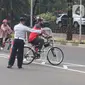 Petugas mengarahakan pesepeda non road bike saat memasuki JLNT Kampung Melayu-Tanah Abang, Jakarta, Minggu (30/5/2021). Uji coba kedua ini bertujuan kembali mendapatkan masukan dari penggiat sepeda secara lengkap baik dari sisi operasional maupun teknis kedepannya. (Liputan6.com/Herman Zakharia)