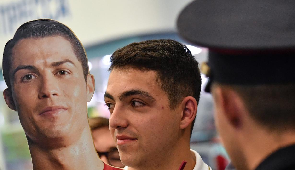 Suporter Portugal membawa patung Cristiano Ronaldo saat tiba di Bandara Zhukovsky, Moskow, Sabtu (9/6/2018). CR 7 akan berjuang bersama Portugal pada ajang Piala Dunia 2018 Rusia. (AFP/Yuri Kadobnov)