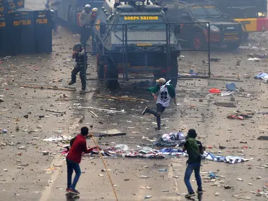 Polisi menembakkan gas air mata ke arah mahasiswa saat demonstrasi menolak pengesahan RUU KUHP dan revisi UU KPK di depan Gedung DPR, Jakarta, Selasa (24/9/2019). Polisi menghalau mahasiswa yang berusaha masuk ke area Gedung DPR. (merdeka.com/Arie Basuki)