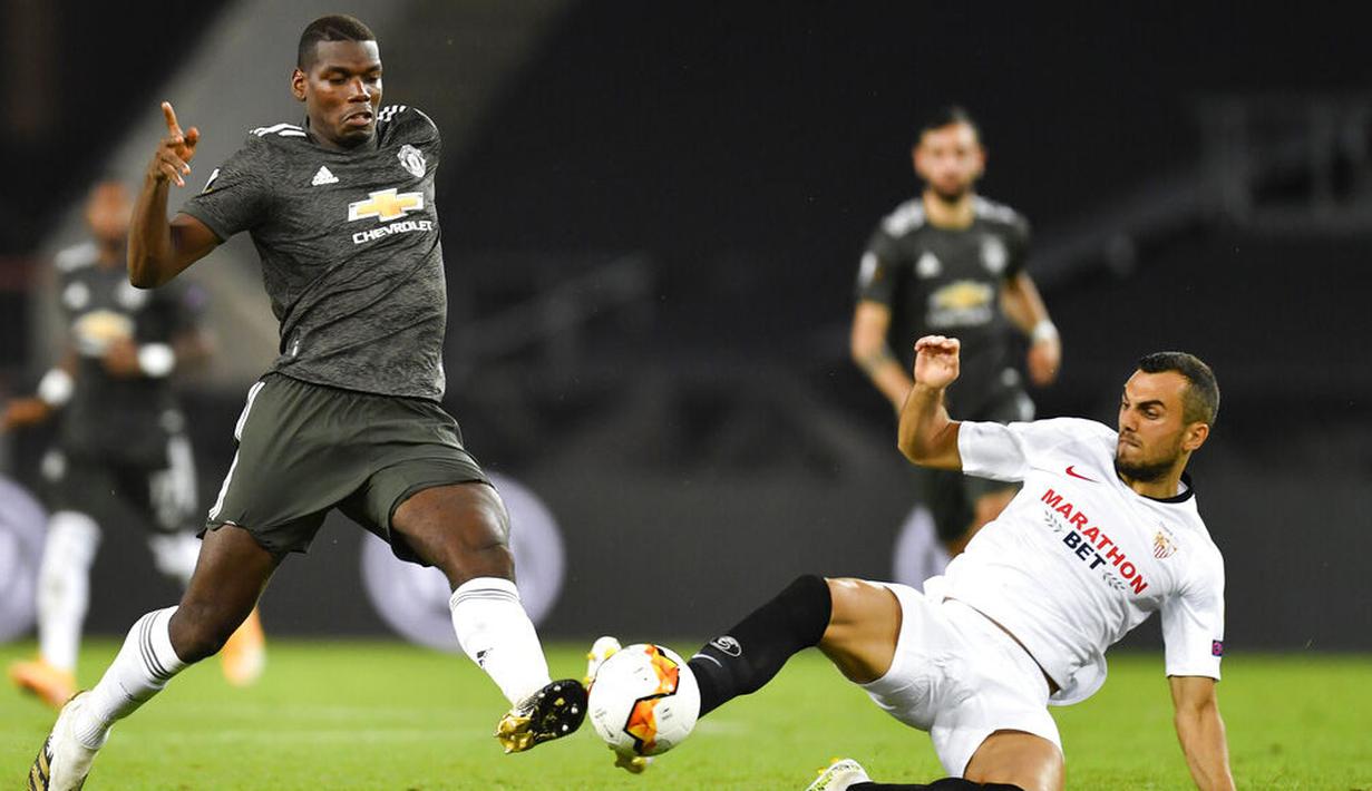 Pemain Sevilla, Joan Jordan, berebut bola dengan pemain Manchester United, Paul Pogba, pada laga semifinal Liga Europa di Stadion RheinEnergie, Senin (17/8/2020). Sevilla menang 2-1 atas Manchester United. (Marius Becker/dpa via AP)