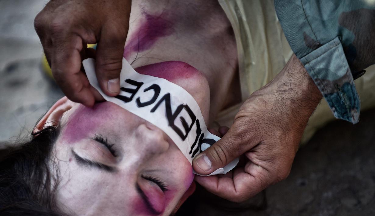 Aktivis Spanyol Jil Love saat melakukan aksi di Mexico City, Meksiko (27/8). Selain bermake-up wajah babak belur, Tubuh mereka pun juga dibungkus lakban saat melakukan aksinya di pusat kota. (AFP Photo / Pedro Pardo)