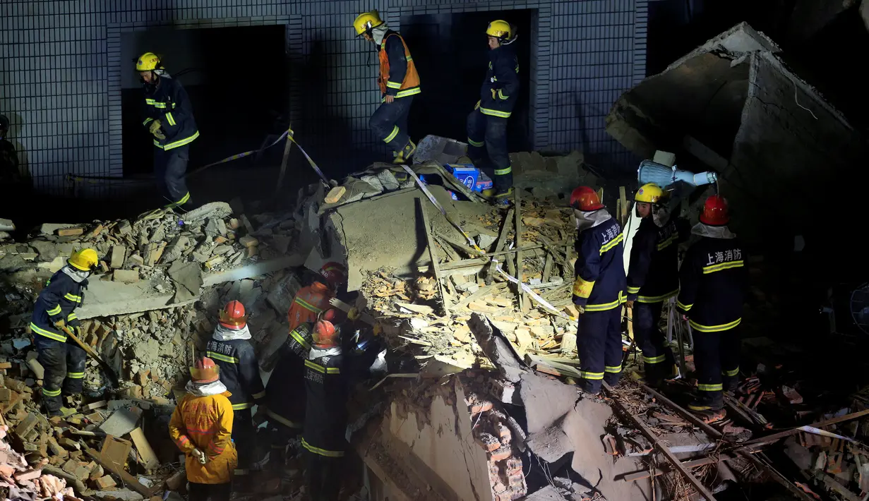 Sejumlah petugas menyisir lokasi bangunan tiga lantai perumahan yang runtuh di Shanghai, China, Senin (11/4). Belum jelas berapa kerugian dan korban jiwa dan luka dalam kejadian ini. (REUTERS/Aly Song
