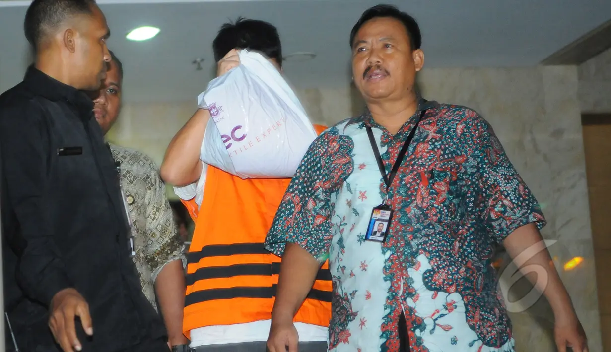 Direktur PT Mitra Maju Sukses, Andrew Hidayat menutup wajahnya usai menjalani pemeriksaan di Gedung KPK, Jakarta, Sabtu (11/4/2015), dini hari. Andrew ditangkap KPK bersama barang bukti uang senilai  US$ 90.000. (Liputan6.com/Herman Zakharia)