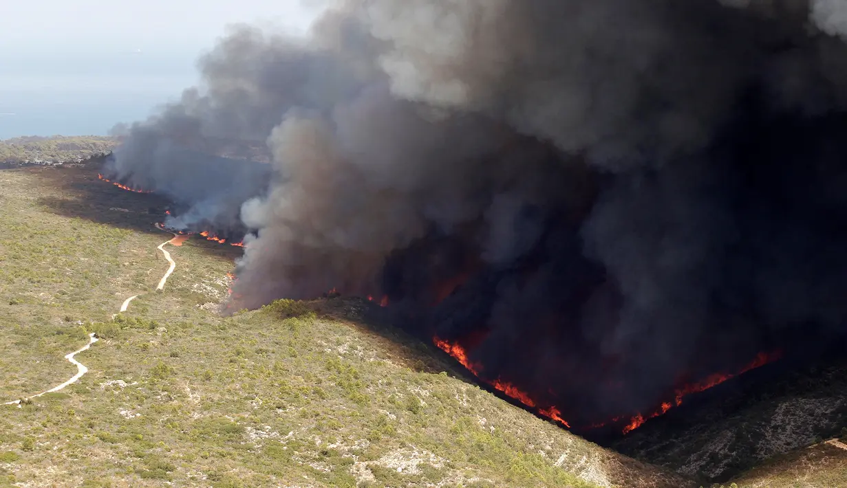 Kebakaran hutan terus menjalan hingga ke area wisata di Benitatxell dekat Alicante, Spanyol, Senin (5/9). Belum diketahui secara pasti apa penyebab kebakaran hutan tersebut. (REUTERS / Heino Kalis)