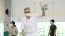 PM Lee Hsien Loong melambai saat memberikan suara dalam pemilu di TPS Sekolah Dasar Alexandra, Singapura, Jumat (10/7/2020). Pemilu di tengah pandemi COVID-19, warga Singapura memberikan suara dengan mengenakan masker dan sarung tangan plastik. (Ministry of Communications and Information via AP)