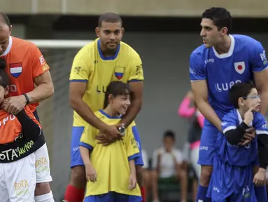 Sejumlah anak berkebutuhan khusus dan pesepakbola Brasil bermain bola saat menghadiri "World Boots" di Neymar Institute, Brasil, 7 Juni 2015. Acara tersebut diadakan pesepakbola Brasil Neymar untuk anak-anak berkebutuhan khusus. (REUTERS/Paulo Whitaker)
