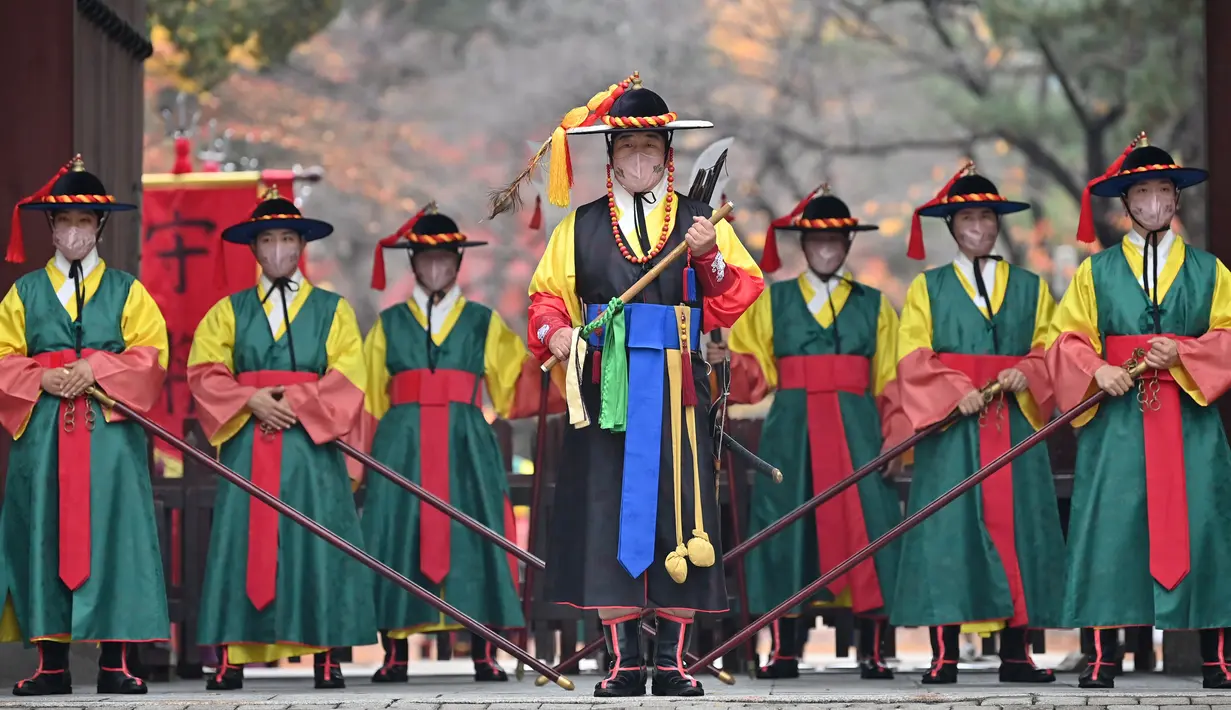 Anggota penjaga istana dengan mengenakan masker ambil bagian dalam upacara pergantian penjaga bagi wisatawan di gerbang utama Istana Deoksugung di Seoul, Rabu (18/11/2020). Upacara Pergantian Penjaga Kerajaan diadakan mulai hari Selasa hingga Minggu, sebanyak tiga kali sehari. (Jung Yeon-je AFP)