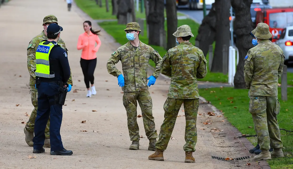 Petugas kepolisian dan tentara berpatroli di jalur lari yang populer di Melbourne, Selasa (4/8/2020). Melbourne memasuki pembatasan Tahap 4 dengan aturan yang lebih ketat sebagai upaya untuk membatasi pergerakan masyarakat dan penyebaran COVID-19. (William WEST / AFP)