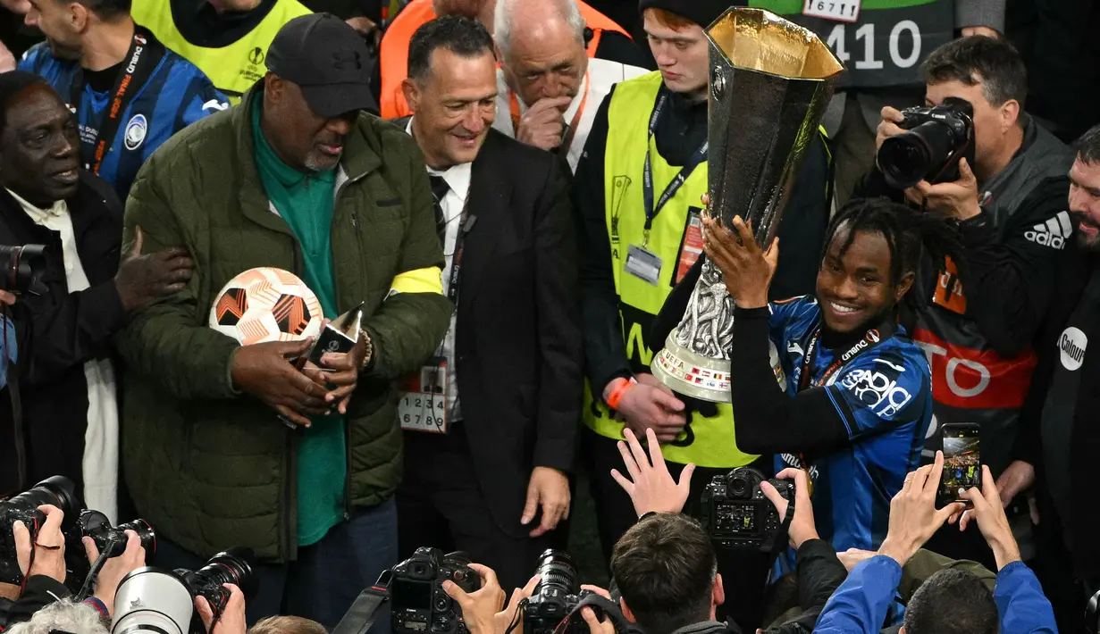 Pemain Atalanta, Ademola Lookman (kanan) mengangkat trofi saat merayakan gelar juara Liga Europa 2023/2024 bersama keluarganya setelah laga final melawan Bayer Leverkusen di Dublin Arena, Irlandia, Kamis (23/05/2024) dini hari WIB. (AFP/Oli Scarff)