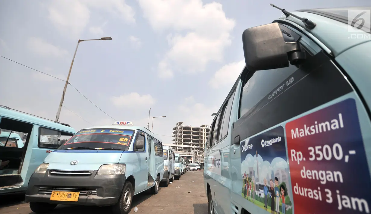 Angkot terparkir bersebelahan dengan mobil OK Otrip saat mangkal di Terminal Kampung Melayu, Jakarta, Selasa (10/7). Hingga saat ini baru dua operator angkot yang bergabung dengan program OK Otrip. (Merdeka.com/Iqbal Nugroho)