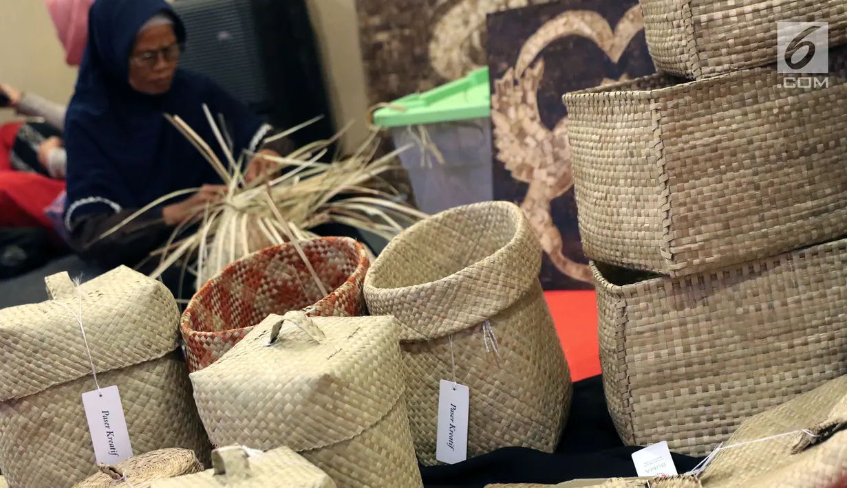 Kerajinan ayaman berlatar pengrajin terlihat di salah satu stand KriyaNusa 2018 di Jakarta Convention Center, Jakarta, Sabtu (29/9). Kali ini, KriyaNusa mengangkat tema Tingkatkan Sinergitas dan Kreativitas Wirausaha. (Liputan6.com/Helmi Fithriansyah)