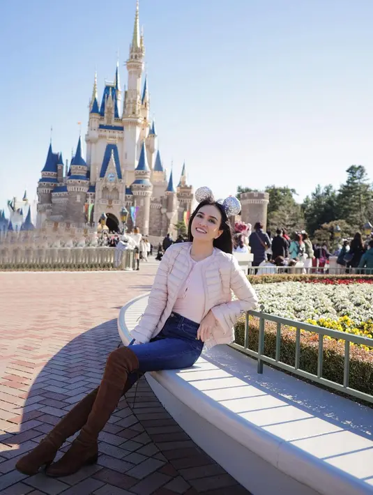 Pose cantik Shandy Aulia di Disneyland. Ia mengenakan innerwear putih, dilapisinya dengan puffer jacket yang juga berwarna putih, dipadu dengan celana jeans, dan high boots cokelat. Tak lupa sentuhan bando mickey mouse sebagai pemanis. Foto: Instagram.