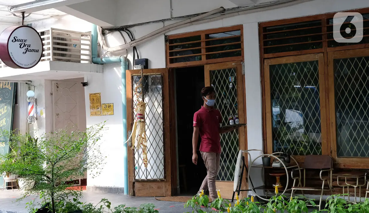 Pekerja mengantar jamu untuk pelanggan di kafe Suwe Ora Jamu, kawasan M Bloc, Jakarta, Jumat (10/7/2020). Kebiasaan mengonsumsi jamu di masa pandemi COVID-19 sangat baik untuk meningkatkan imunitas tubuh. (Liputan6.com/Herman Zakharia)