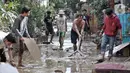 Sejumlah warga membersihkan lumpur di sekitar rumah usai banjir menerjang Perumahan Pondok Gede Permai, Jatiasih, Bekasi, Jawa Barat, Kamis (2/1/2020). Terjangan banjir setinggi lima meter tersebut menyisakan lumpur dan sampah yang memenuhi seluruh kompleks perumahan. (merdeka.com/Iqbal Nugroho)