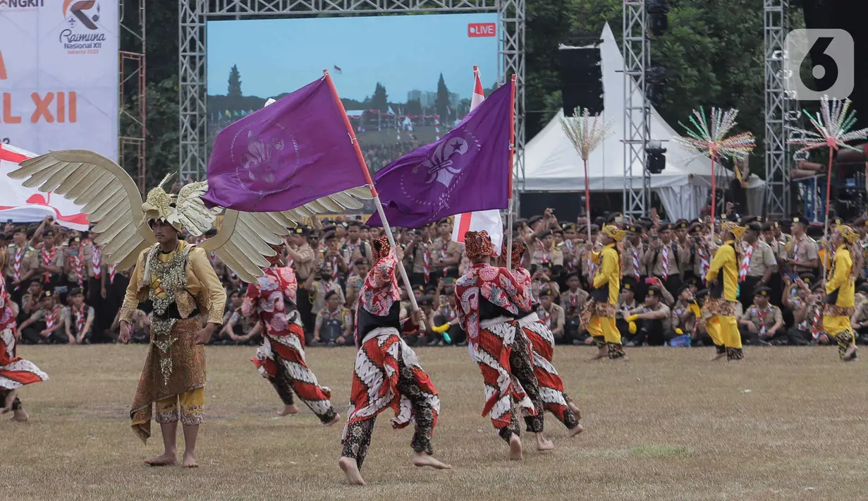 Gabungan anggota Pramuka memakai pakaian adat saat melakukan tarian kolosal pada HUT ke-62 Pramuka di Buperta, Cibubur, Jakarta Timur, Senin (14/8/2023). (Liputan6.com/Herman Zakharia)