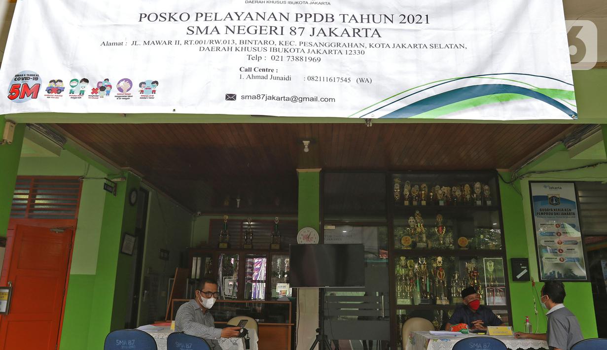 Orang tua murid mencari informasi pengajuan akun untuk mengikuti proses Penerimaan Peserta Didik Baru (PPDB) Tahun Pelajaran 2021/2022 di SMA Negeri 87 Jakarta, Senin (7/6/2021).  Proses PPDB DKI Jakarta yang mulai dibuka sejak hari ini, Senin (7/6). (Liputan6.com/Herman Zakharia)